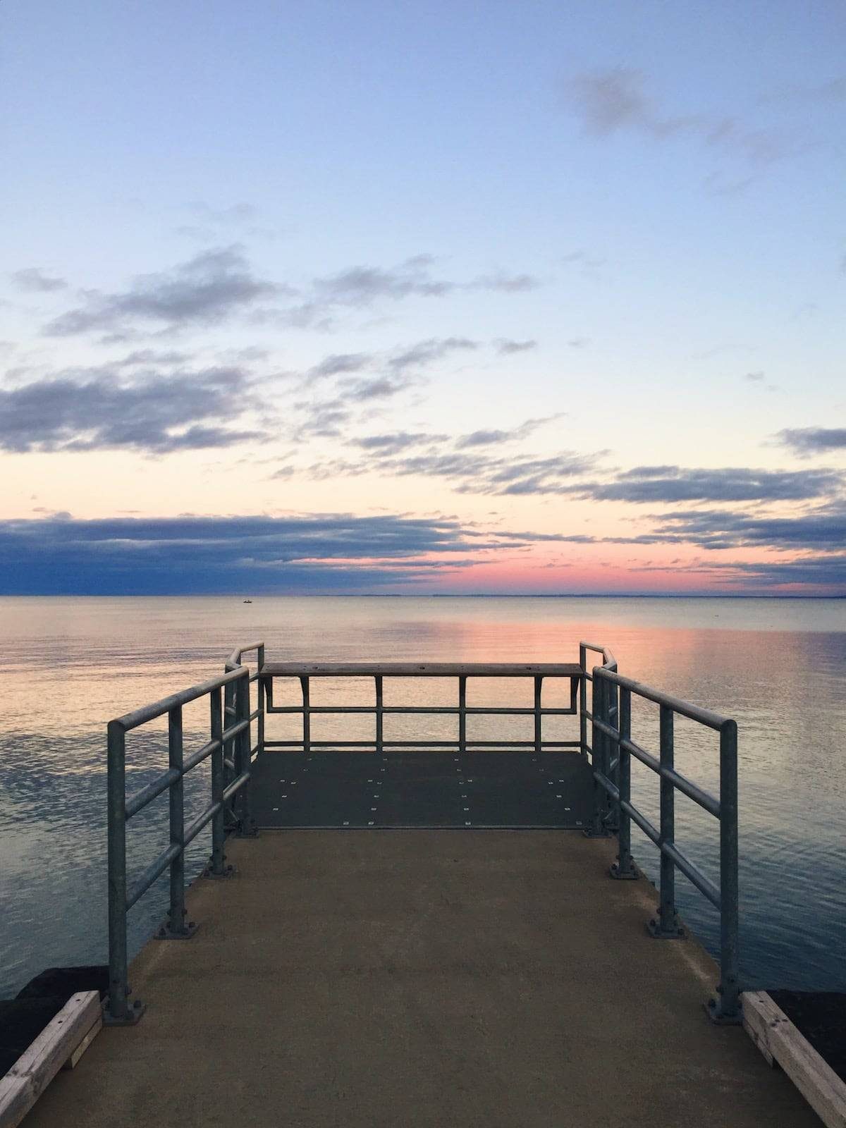 Sunset over the lake looking out on a dock.