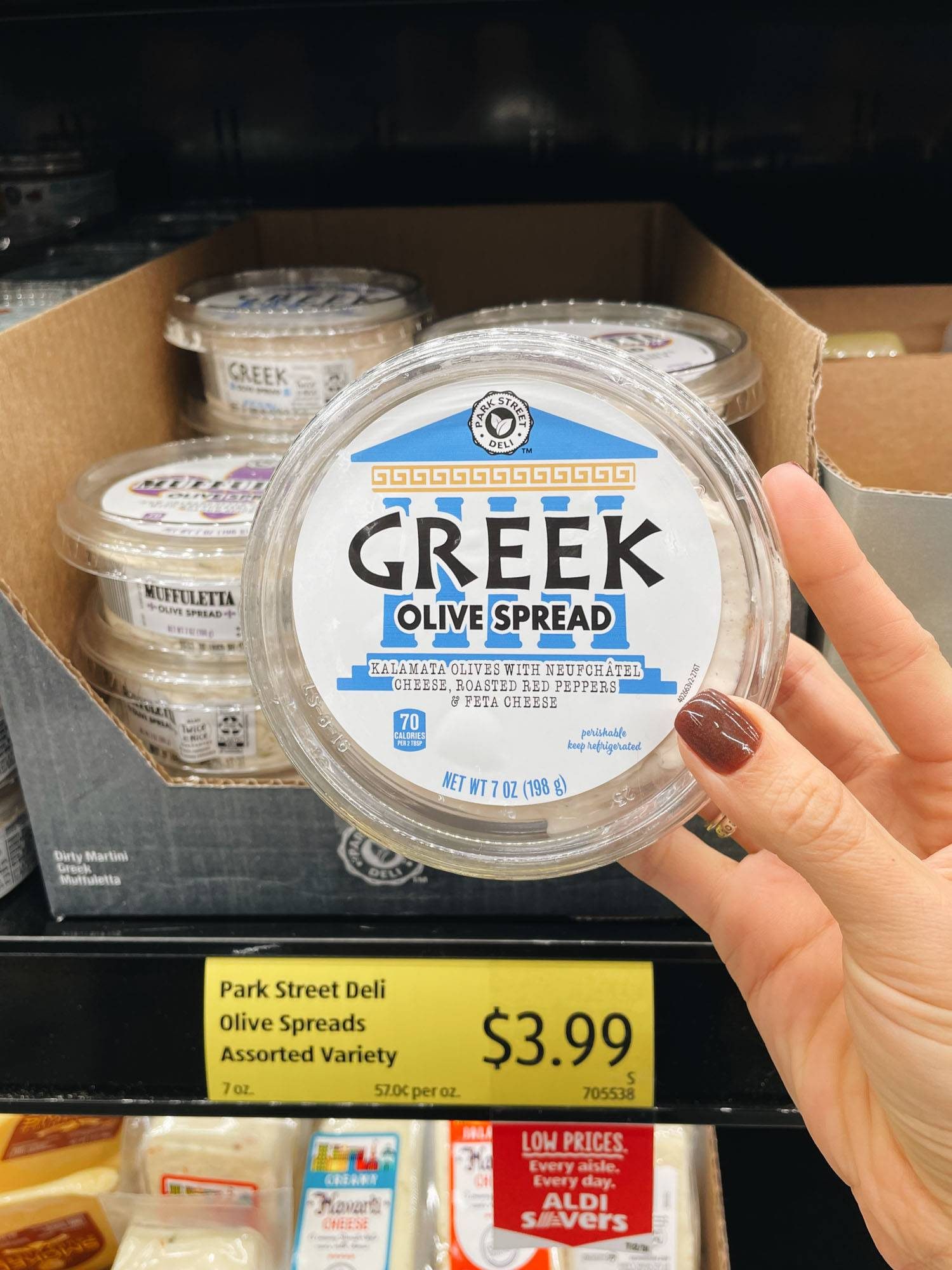 White hand holding greek olive spread