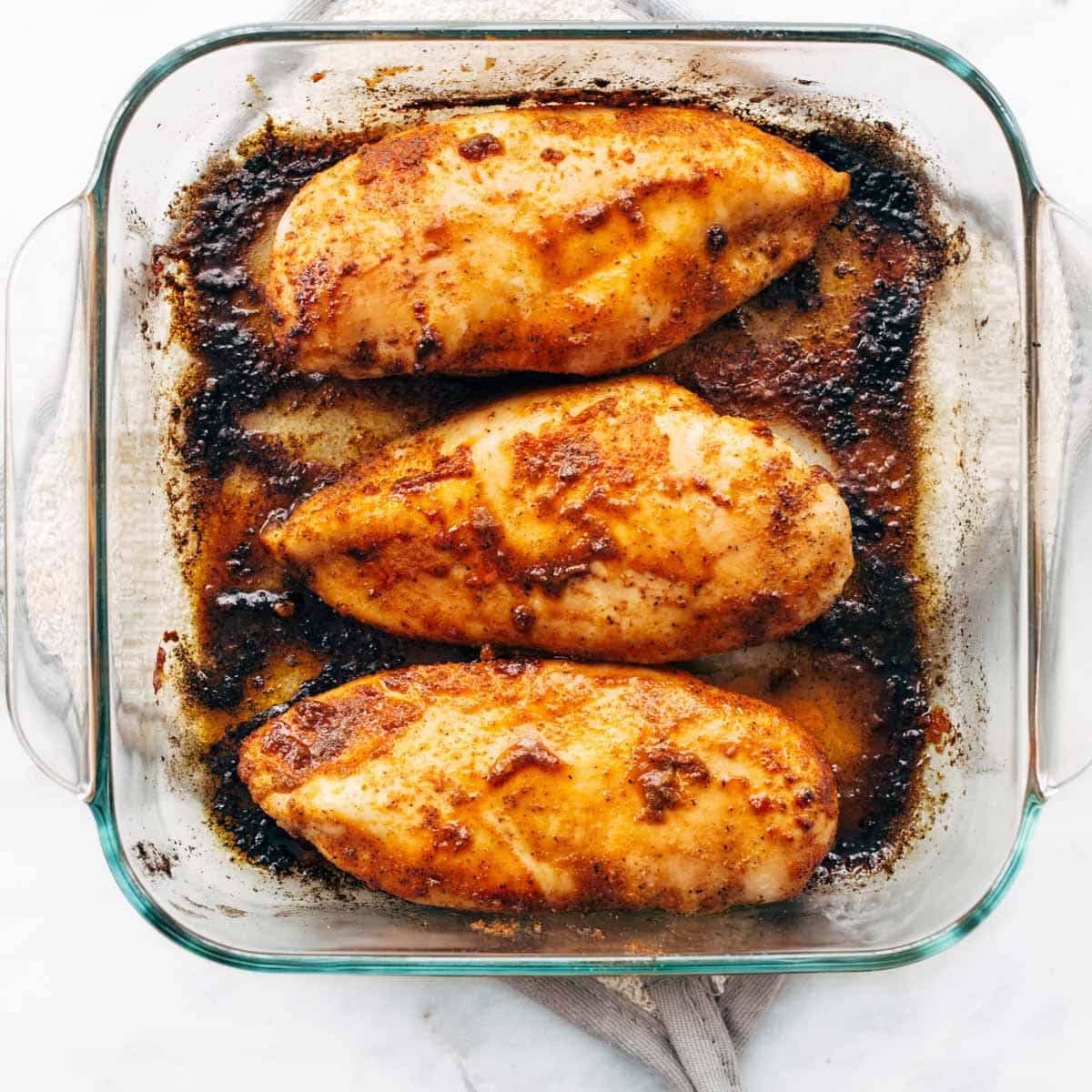 Baked chicken breasts in a pan.