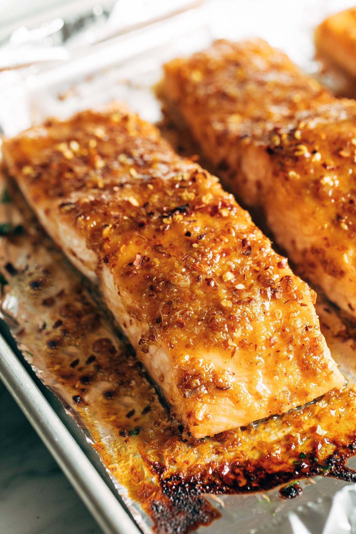 Hot honey salmon on a sheet pan lined with foil.