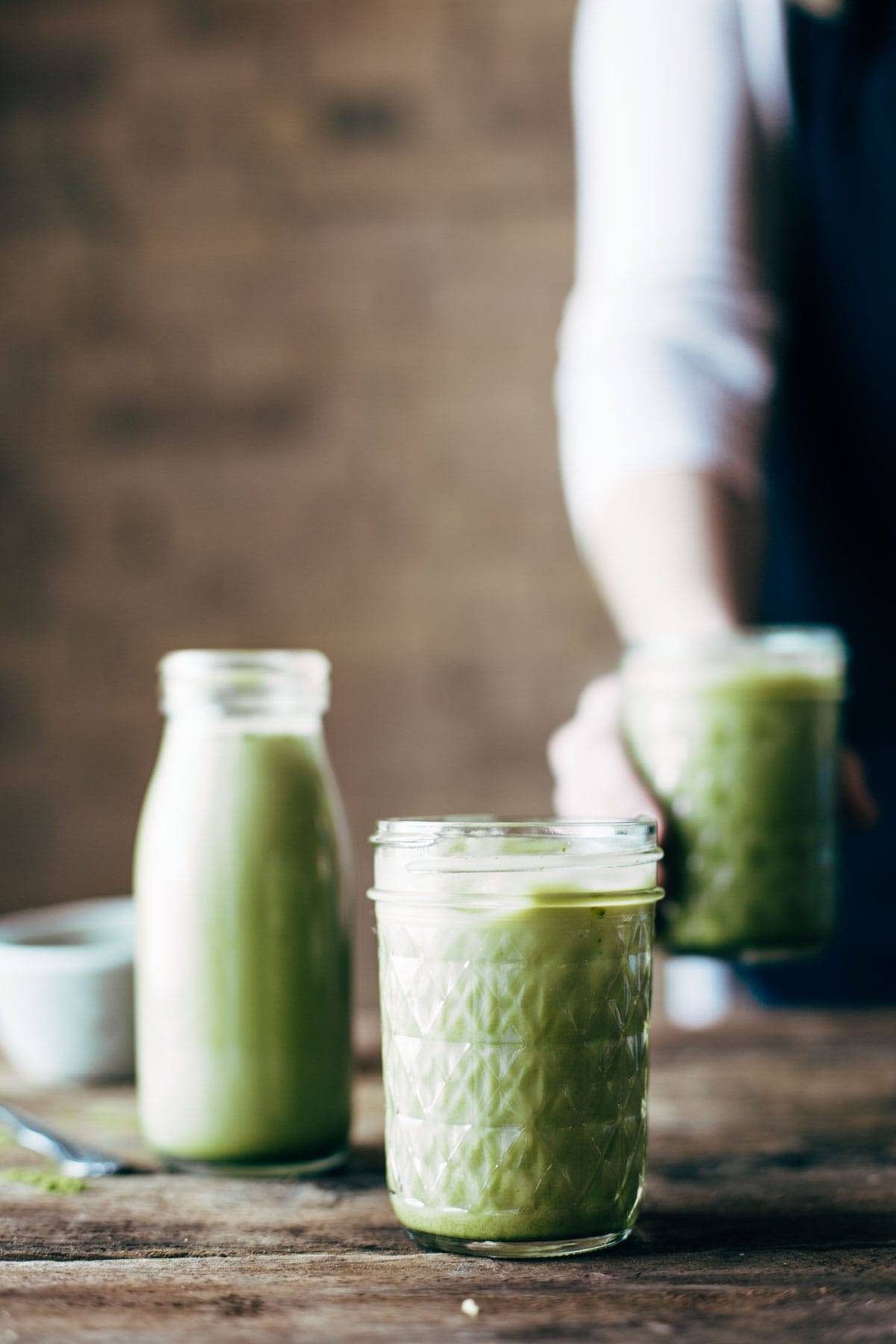 Mason jars filled with iced matcha green tea latte. 