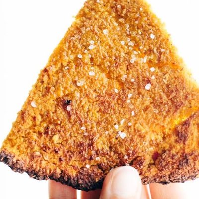 Sweet Potato Pizza Crust slice held by hand.