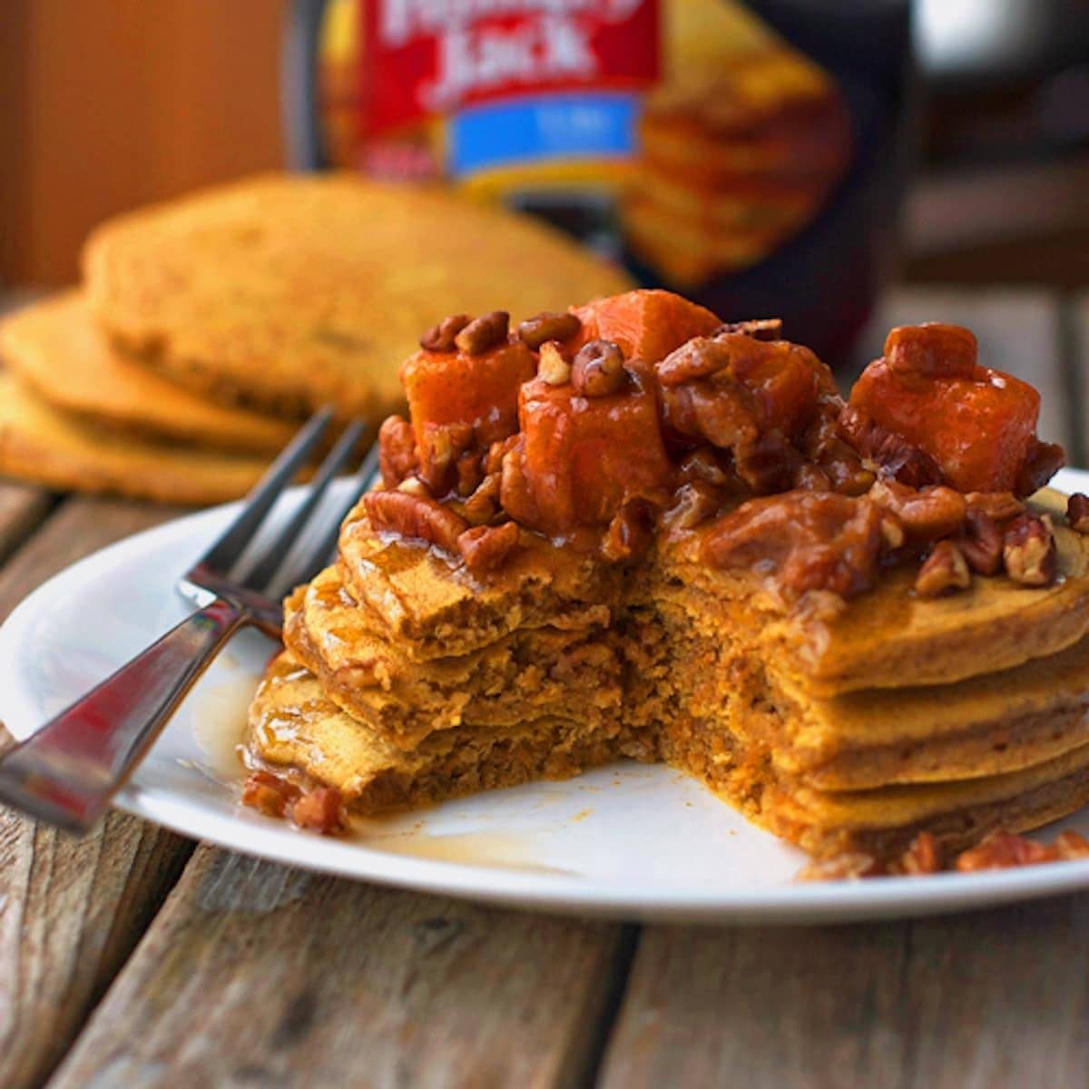 Butternut squash pecan pancakes topped with pecans and maple syrup. 