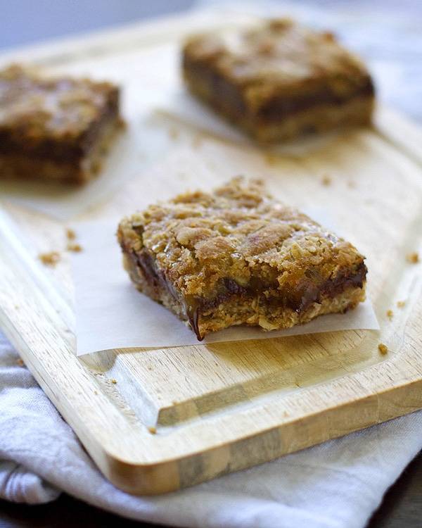 Chocolate caramel oatmeal bars on a cutting board.