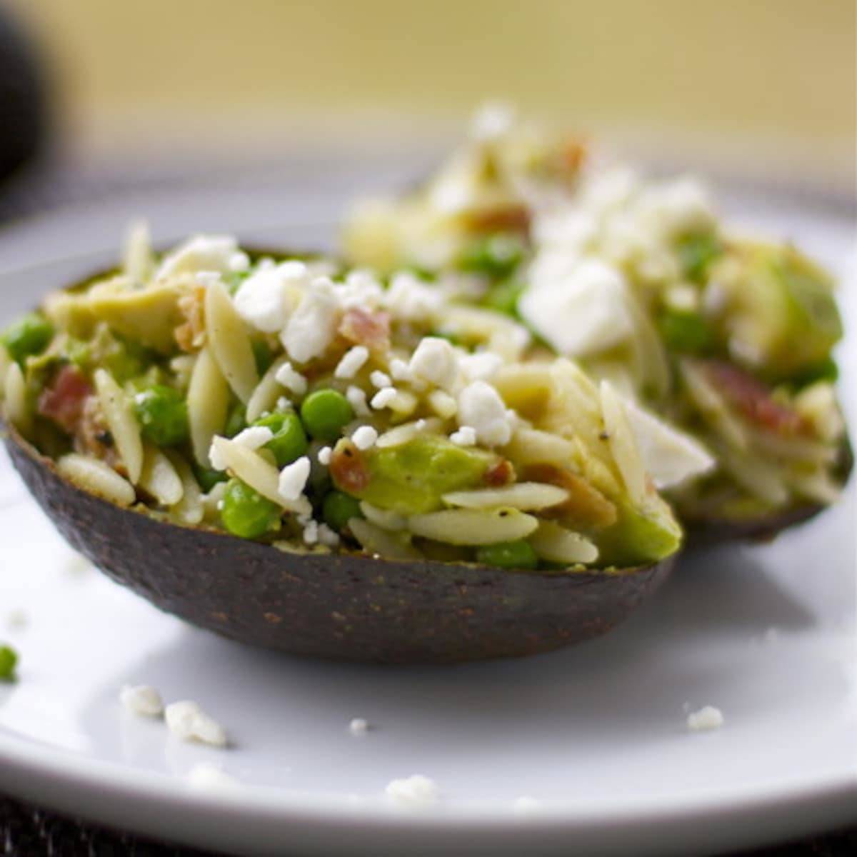 Avocado Bacon Orzo with feta cheese served in an avocado peel.