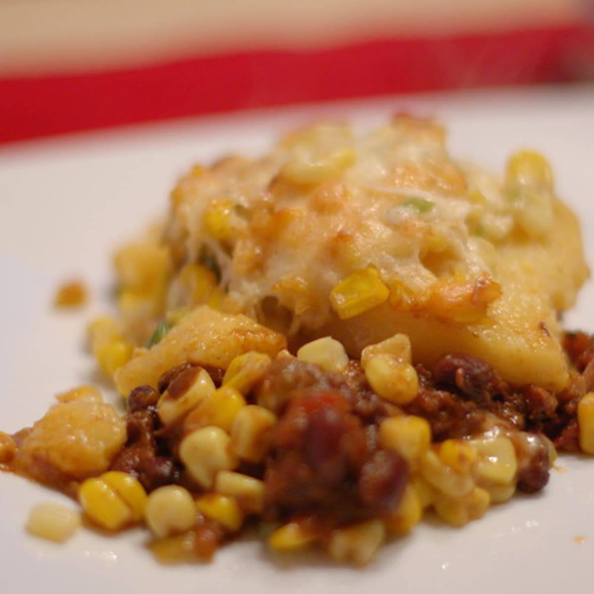 Chili-corn casserole with polenta  on a white surface.