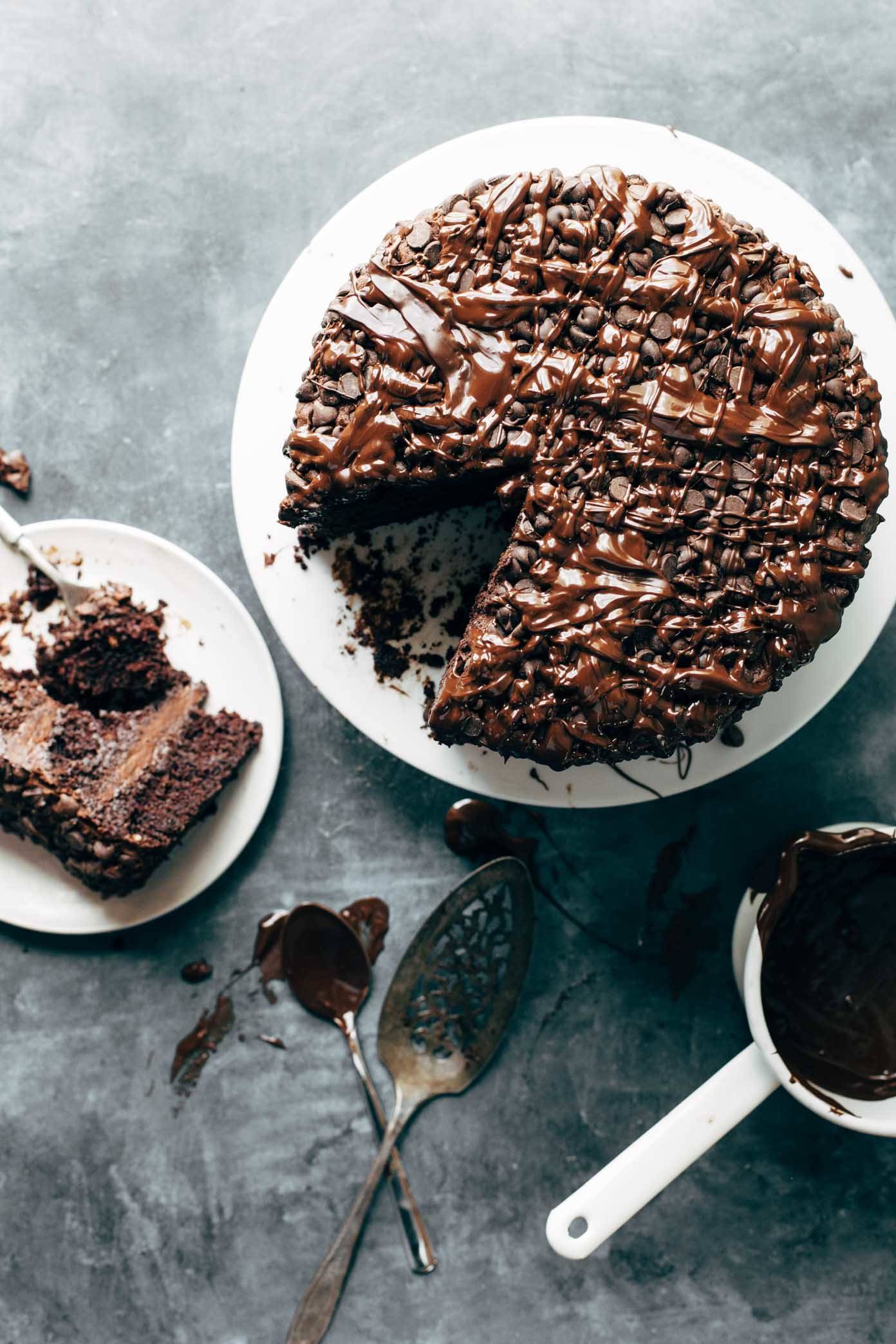 Blackout Chocolate Cake on a cake stand with a plate and utensils