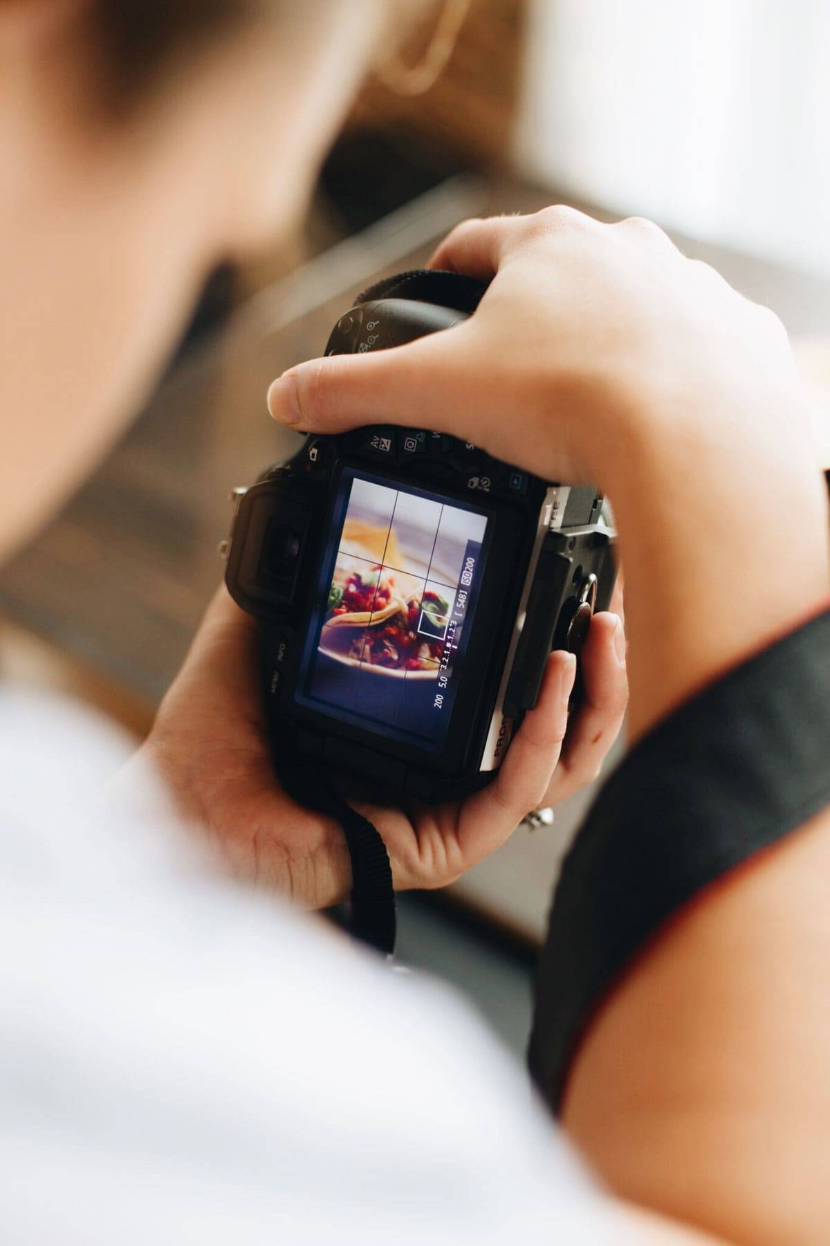 Person holding a camera taking a photo of food.