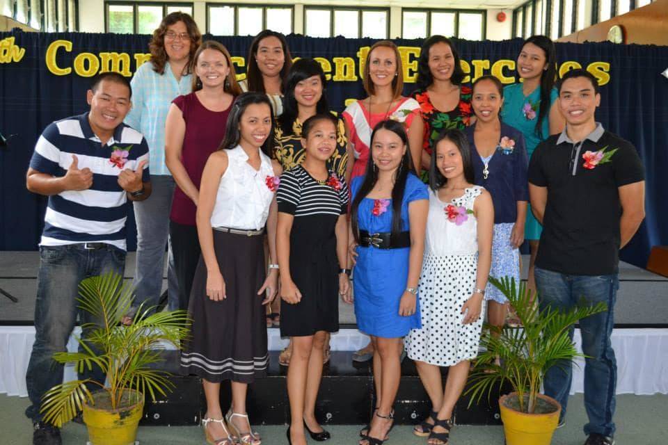 Group of people standing and smiling.