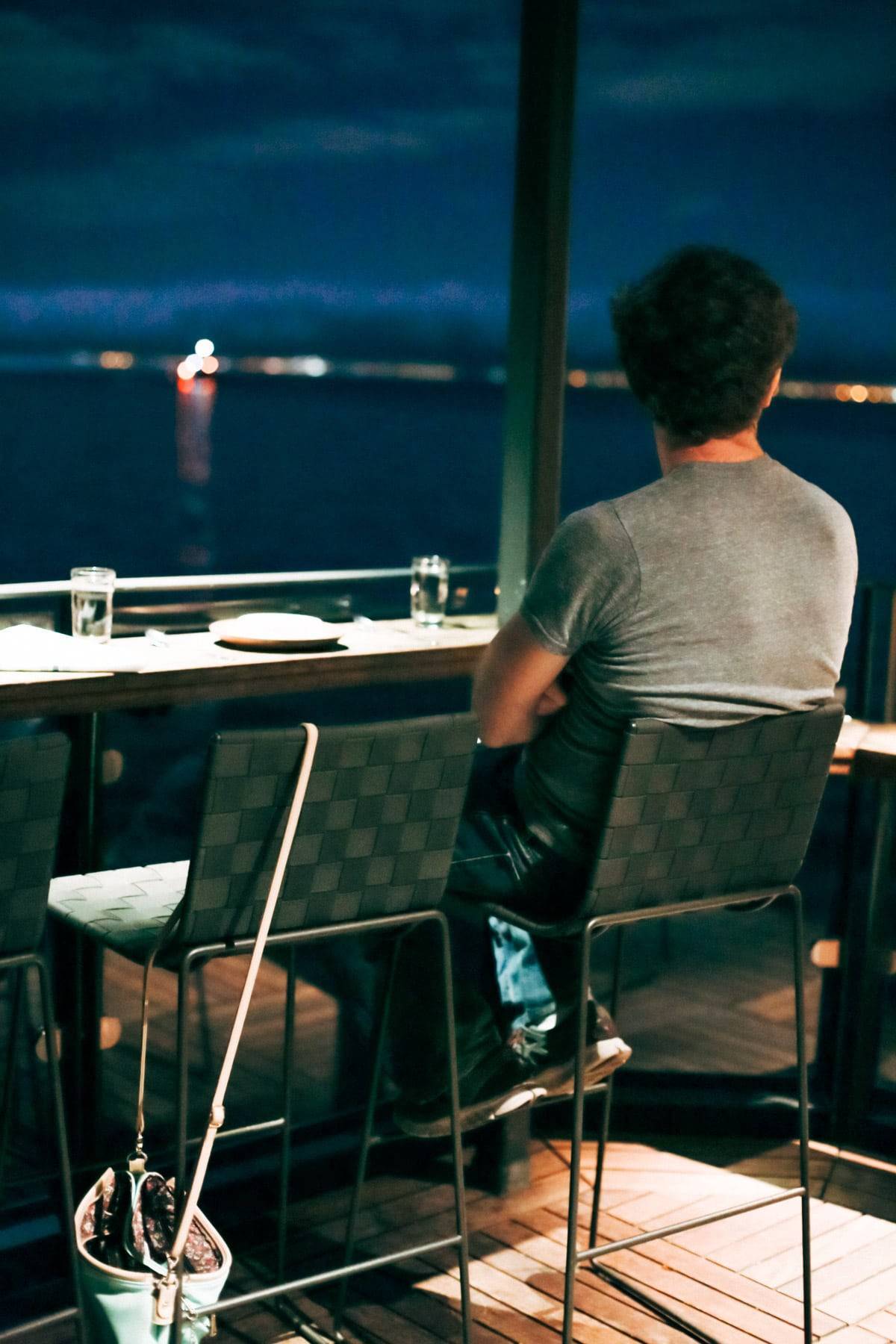 Man sitting in a chair looking out at the water.