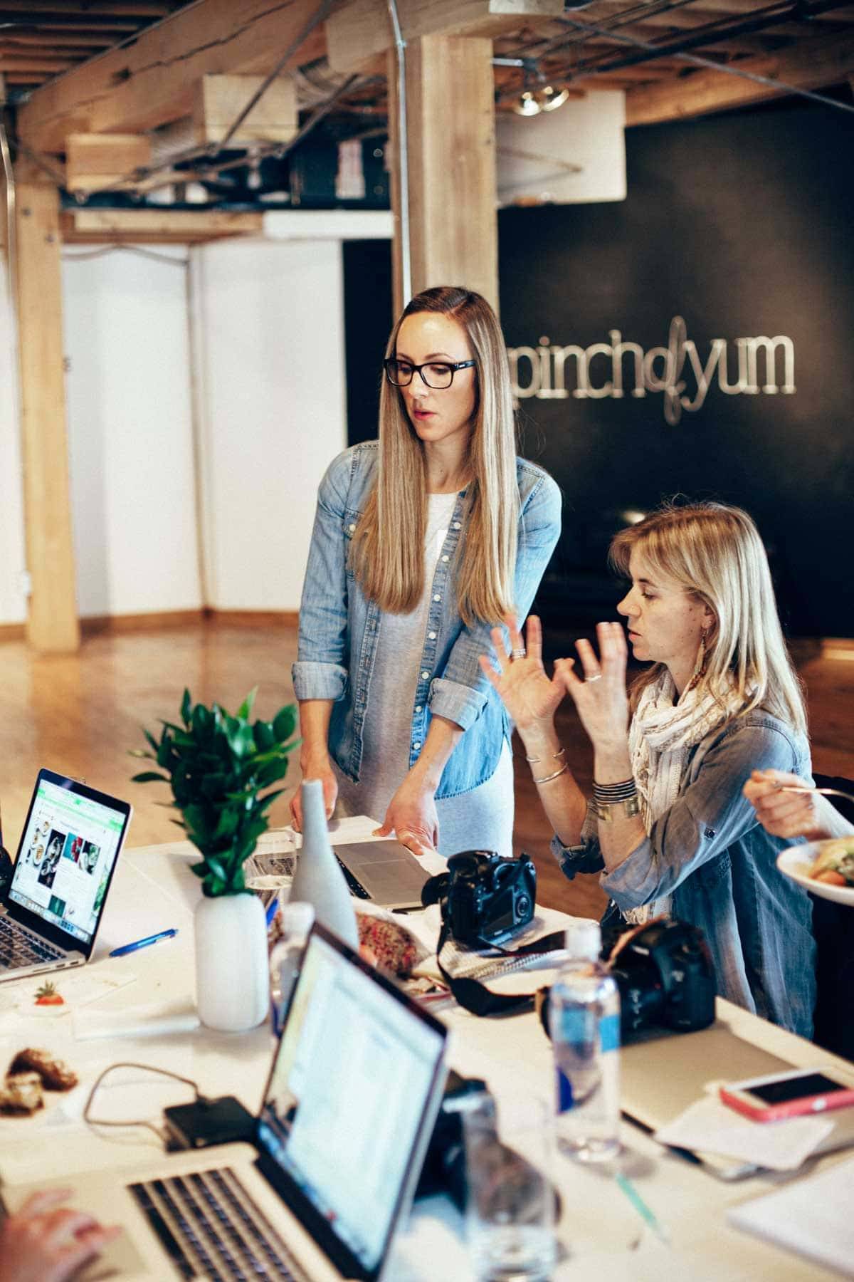 Two women talking while looking at a computer screen.